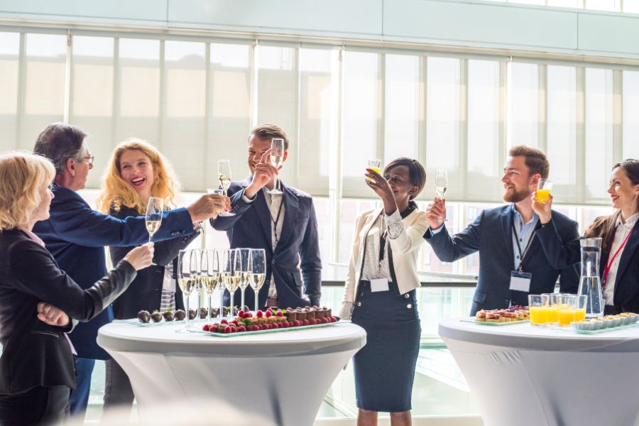 Corporate professionals celebrating a successful event planning process with a toast during a business gathering.
